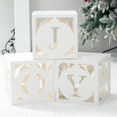 Papírové boxy s písmeny JOY a sněhovými vločkami